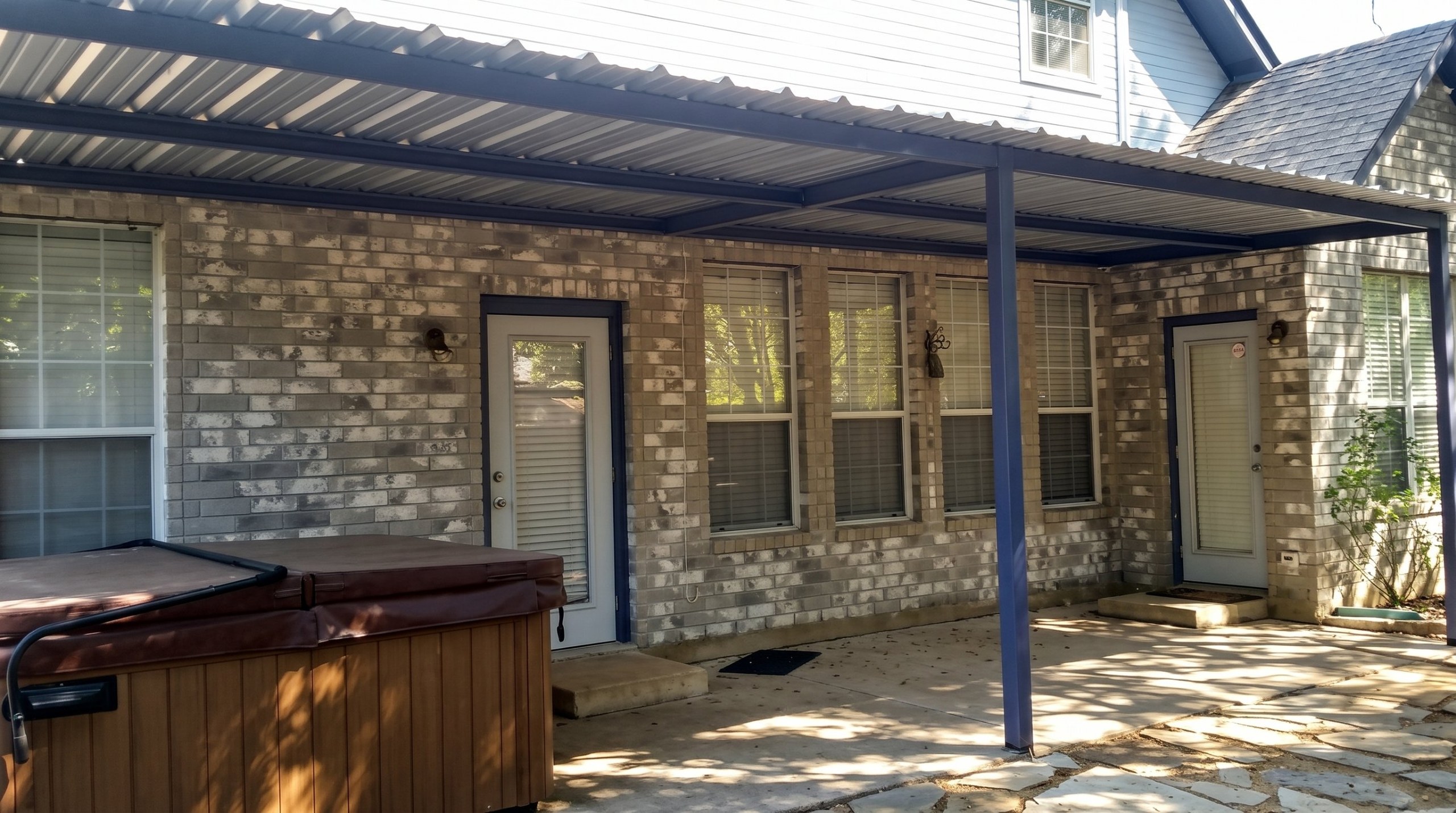 Steel patio cover attached to a brick house in San Antonio, Texas